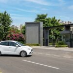 Sedan taxi driving past a Mohali residential phase entrance signboard