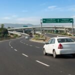 Sedan taxi on a highway junction road with signboards toward Chandigarh and Panchkula